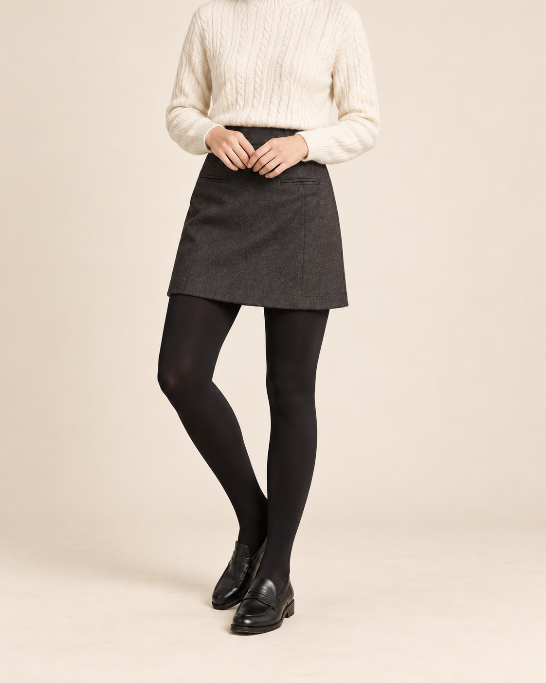 Onyx opaque black tights with a charcoal skirt, ivory sweater and black loafers; shoulders-down view