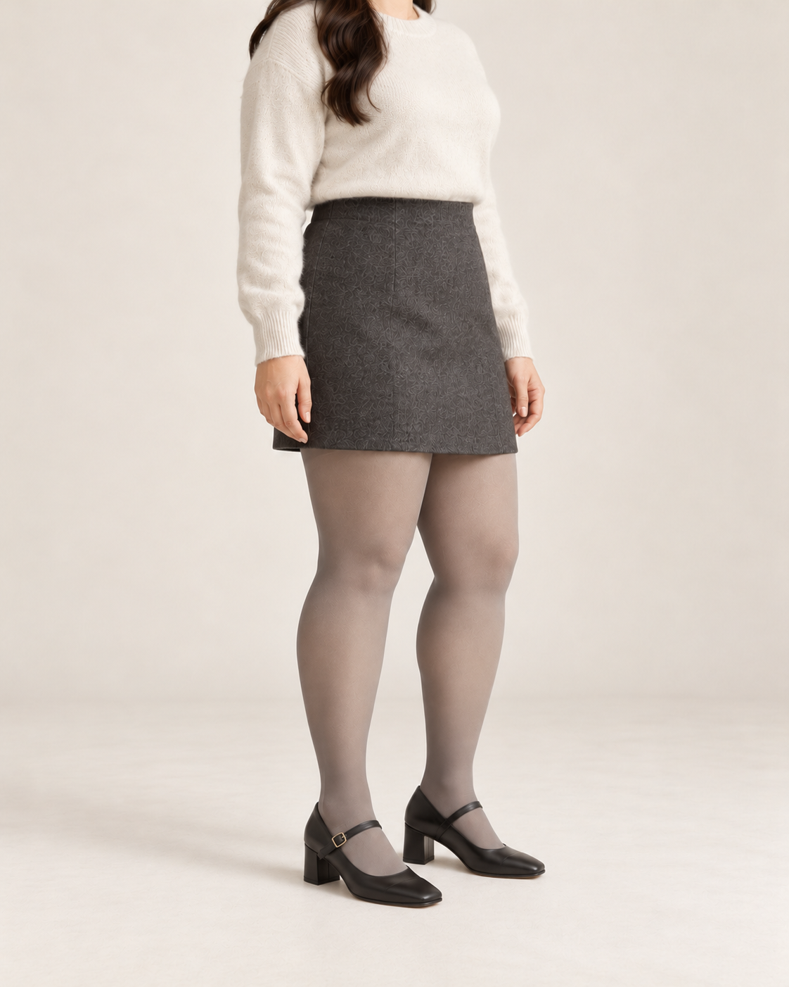 Smoke tights on a fuller-figure adult model in an ivory sweater and skirt, three-quarter studio view; Plus styling illustration